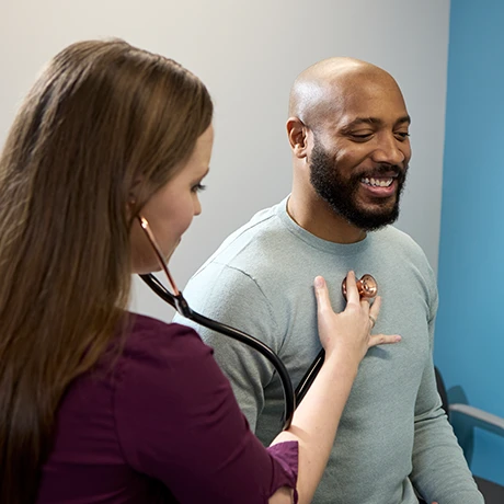 Provider using a stethoscope to listen to a patient's heartbeat
