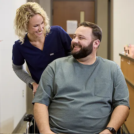Nurse with a male patient at an urgent care, taking him back to the exam room